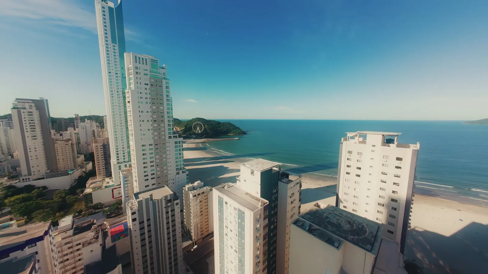 Prédios altos à beira da praia em um dia de céu azul