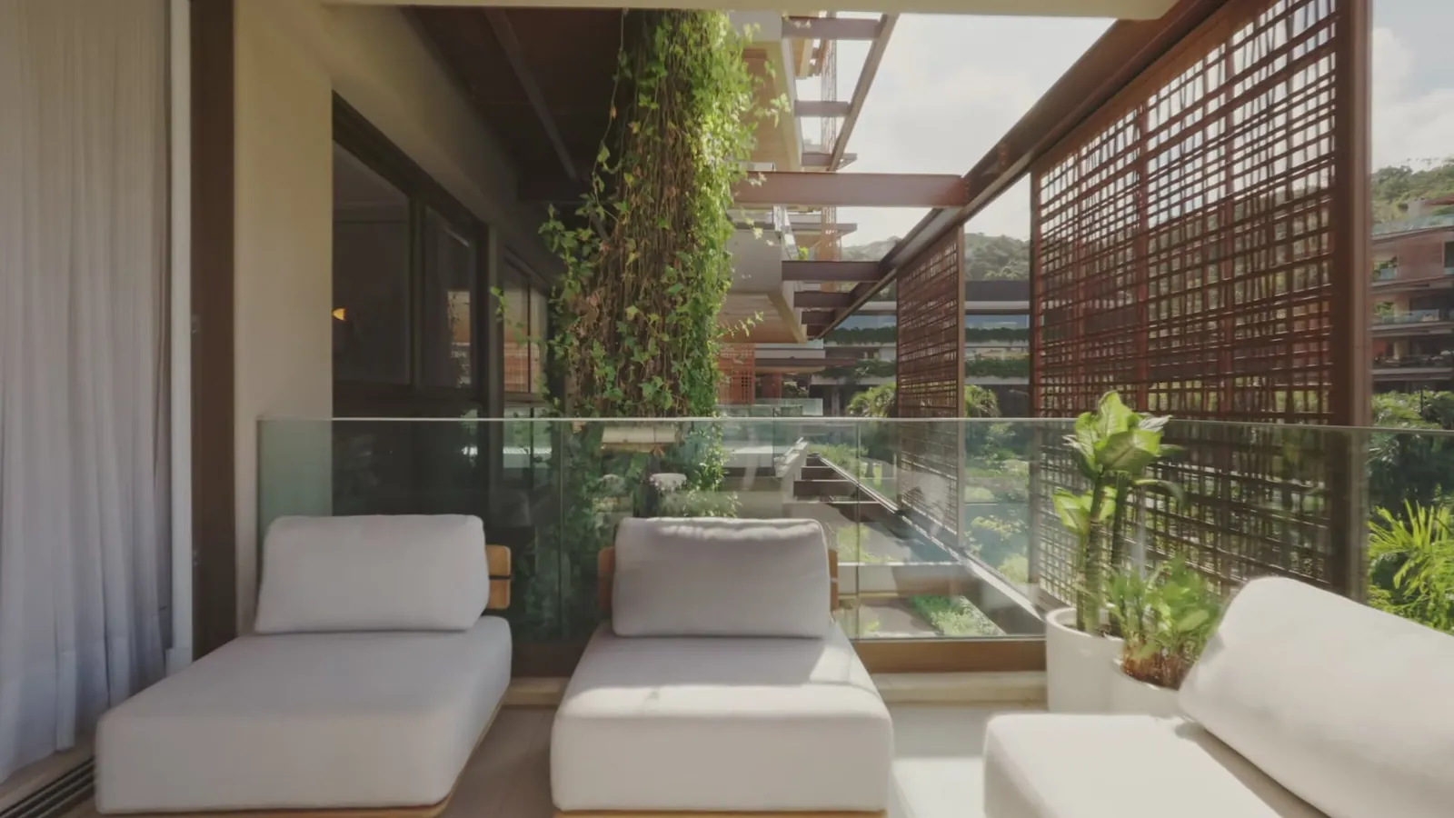 Varanda com poltronas brancas e parede de plantas